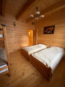 um quarto com 2 camas num chalé de madeira em Nowica 71 Dom Jodłowy em Nowica