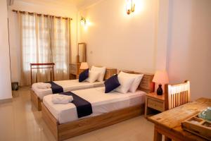 1 Schlafzimmer mit 2 Betten und einem Tisch in der Unterkunft Biosphere Inn in Dharavandhoo