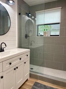 uma casa de banho com um chuveiro, um lavatório e um espelho. em Farmhouse in Taylor, 4 min to Samsung campus em Taylor