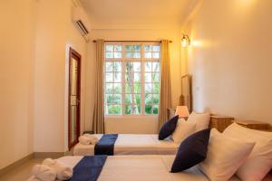 1 dormitorio con 2 camas y ventana en Biosphere Inn, en Dharavandhoo