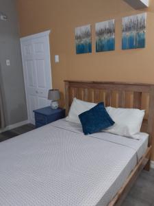 Una cama con una almohada azul encima. en Comfi Spaces en Canaan