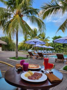 una mesa con platos de comida y bebidas. en KANDORA Luxury villas, en Maujawa