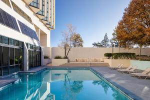 a swimming pool with chairs next to a building at Marriott Albuquerque in Albuquerque