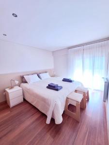 - une chambre avec un grand lit blanc et une fenêtre dans l'établissement Casa Santana, à Moledo