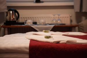 a group of beds with red and white blankets at Hotel U Kaple in Děčín