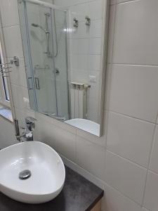 a white bathroom with a sink and a shower at Dimora Nonna Rosa in Aversa