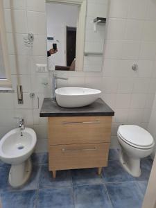 a bathroom with a sink and a toilet and a mirror at Dimora Nonna Rosa in Aversa