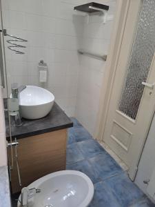 un bagno con lavandino, servizi igienici e porta di Dimora Nonna Rosa ad Aversa