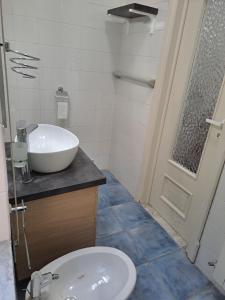 a bathroom with a sink and a toilet and a door at Dimora Nonna Rosa in Aversa