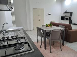 a kitchen with a stove and a table with a bowl of fruit at Dimora Nonna Rosa in Aversa +14 photos
