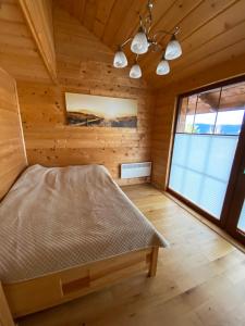a bedroom in a log cabin with a bed at Nowica 71 Dom Jodłowy in Nowica