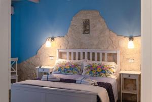 1 dormitorio con 1 cama con pared de roca en Casa della Perla, en Giarre