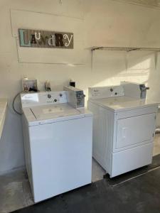 a laundry room with two machines and a sign on the wall at Shares Courtyard Luxury Apt - NEW! in Rockledge