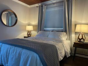 ein Schlafzimmer mit einem Bett, zwei Lampen und einem Spiegel in der Unterkunft Shares Courtyard Luxury Apt - NEW! in Rockledge