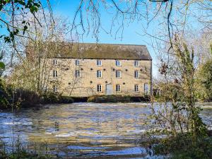 an old stone building next to a river at Willow Cottage 