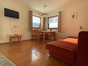 1 dormitorio con 1 cama y 1 mesa con sillas en Brunnerhof, en Strassen