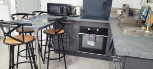 a kitchen with a counter with stools and a stove at MON CHEZ MOI in Le Tampon