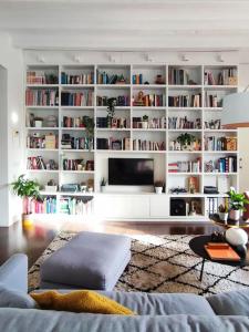 a living room with a large white book shelf at Vivienda con encanto en Tarragona (a 5 min playa) in Tarragona