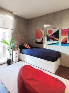 a bedroom with a bed and a red ottoman at Vivienda con encanto en Tarragona (a 5 min playa) in Tarragona