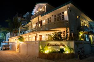 un edificio blanco con un cartel en él por la noche en Biosphere Inn, en Dharavandhoo