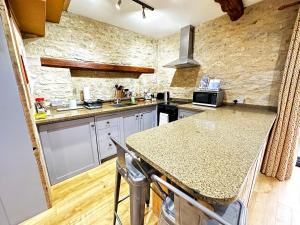 a kitchen with a granite counter top and a kitchen island at Dove House Cottages - No 2 in Witney