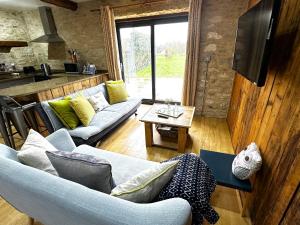 a living room with a couch and a table at Dove House Cottages - No 2 in Witney