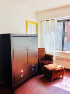 sala de estar con armario y silla en Stylish Montreal Apartment: Comfortable Stay in the Golden Square Mile, en Montreal