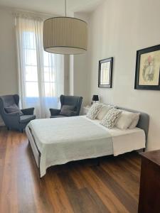 a bedroom with a large bed and two chairs at Santa Rosa Florence Apartments 3 Bedrooms - Private Parking in Florence