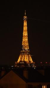 a view of the eiffel tower lit up at night at Joli T2 proche du métro avec vue Tour Eiffel in Issy-les-Moulineaux