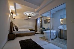 a bathroom with a tub and a bedroom with a bed at Premium Residence in Braşov