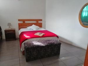 1 dormitorio con 1 cama con manta roja en Descanso del Petrel, en Puerto Ayora