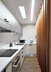 a kitchen with white cabinets and a sink and a stove at Eulalia's House in Modena