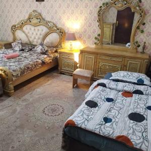 1 dormitorio con cama, tocador y espejo en العين الهيلي مصباح بيت 11, en Al Ain