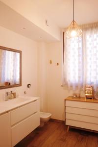 La salle de bains est pourvue d'un lavabo, de toilettes et d'un miroir. dans l'établissement Orea Spiti - Modern Oasis Near Milan, à Assago