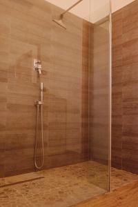 La salle de bains est pourvue d'une douche avec une porte en verre. dans l'établissement Orea Spiti - Modern Oasis Near Milan, à Assago
