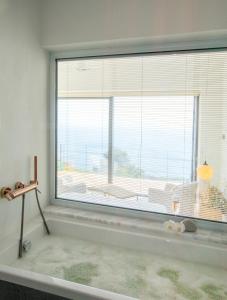 a room with a large window with a view of the ocean at Momos Otel in Ayvacık