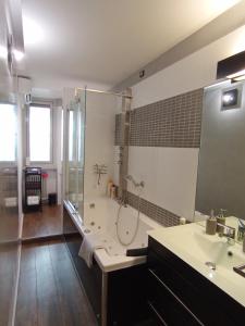 uma casa de banho com uma banheira, um chuveiro e um lavatório. em FrenzHouse - Terraced Apartment close to Rho Fiera and San Siro em Baranzate