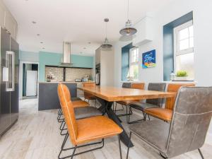 a kitchen and dining room with a wooden table and chairs at Llywnfor in Morfa Nefyn