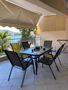 einen Tisch und Stühle auf einer Terrasse mit Aussicht in der Unterkunft Artaki's balcony in Nea Artaki