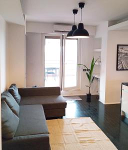 uma sala de estar com um sofá e uma grande janela em FrenzHouse - Terraced Apartment close to Rho Fiera and San Siro em Baranzate