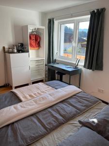 ein Schlafzimmer mit einem Bett und einem Schreibtisch neben einem Fenster in der Unterkunft Central Hideaway in Maria Alm am Steinernen Meer