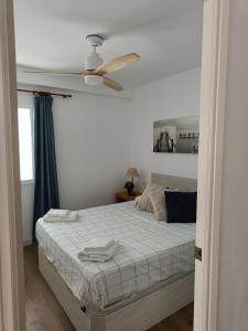 a bedroom with a bed with a ceiling fan at Apartamento con VISTAS AL MAR in Oliva