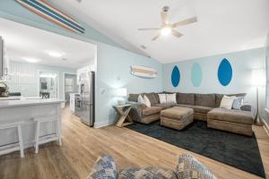 a living room with a couch and a kitchen at Red Neptune by Nautical Properties in Panama City Beach
