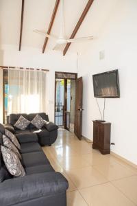 a living room with a couch and a flat screen tv at Apartamento Costa luna in Jacó