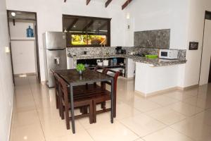 a kitchen with a table and chairs and a refrigerator at Apartamento Costa luna in Jacó