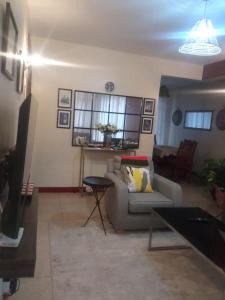 un soggiorno con divano e tavolo di Cosy House near Airport JKIA Train SGR a Nairobi