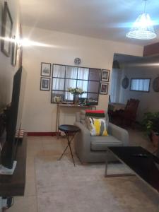 a living room with a couch and a table at Madiniplace 1 - Flexible 1-3BR Apartment near JKIA & SGR in Nairobi