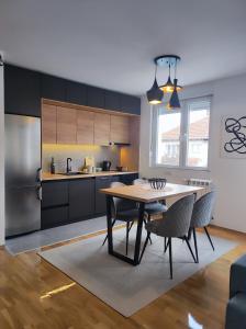 a kitchen and dining room with a table and chairs at Riverside LUX Apartment in Pirot