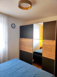 a bedroom with a blue bed and a mirror at Riverside LUX Apartment in Pirot