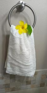 a white towel with a yellow flower on it at Comfi Spaces in Canaan